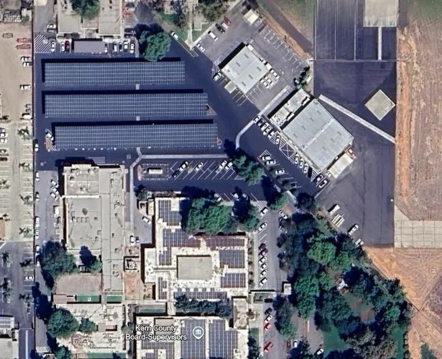 Satellite view — project site, Bakersfield, California, showing the PV parking canopy and rooftop array in place