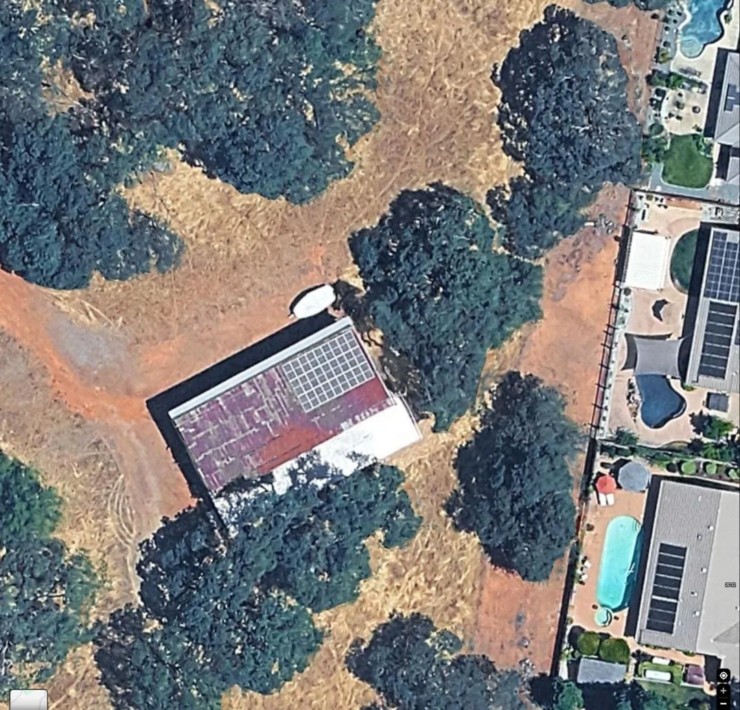 Aerial view of a rural property barn roof with a new solar array installed on one slope