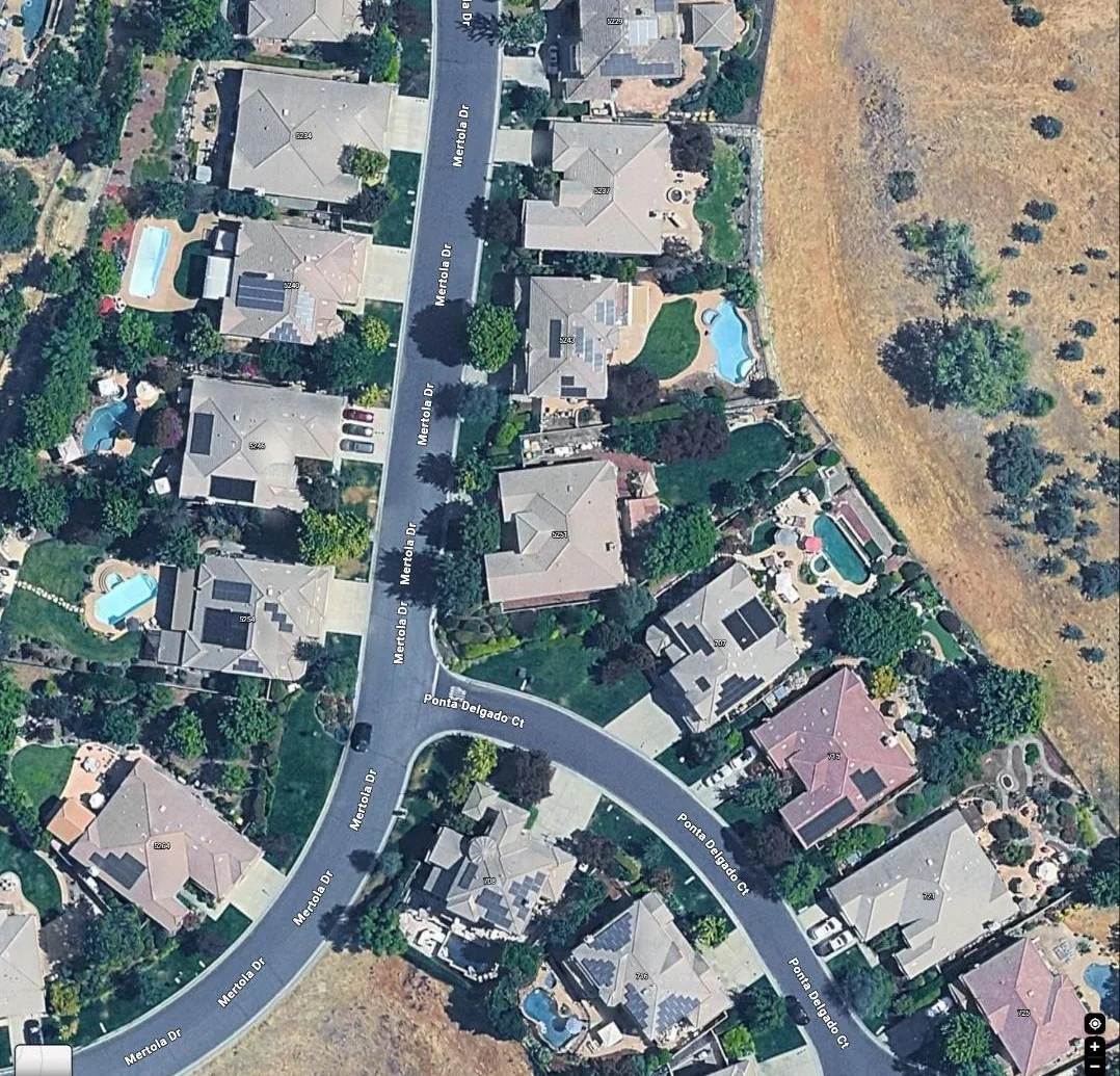 Aerial view of a residential neighborhood street, project site among surrounding homes